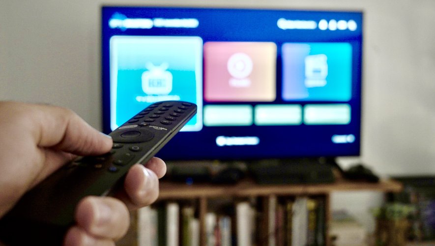 "User using remote control to watch Best IPTV service on Smart TV with IPTV Subscription via IPTV Smarter Pro app